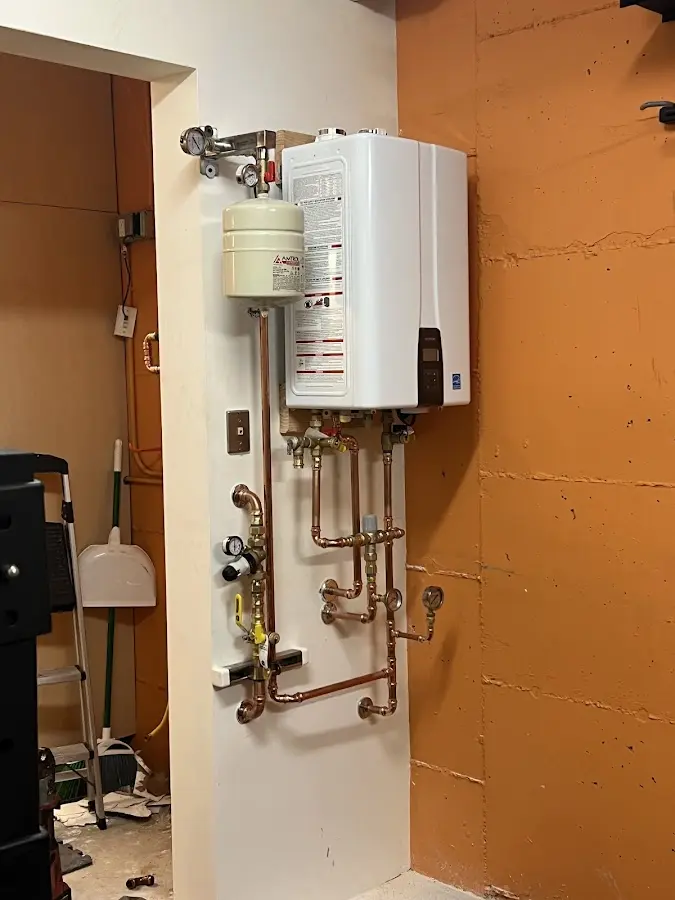 Plumbing technician inspecting water heater connections in Valparaiso